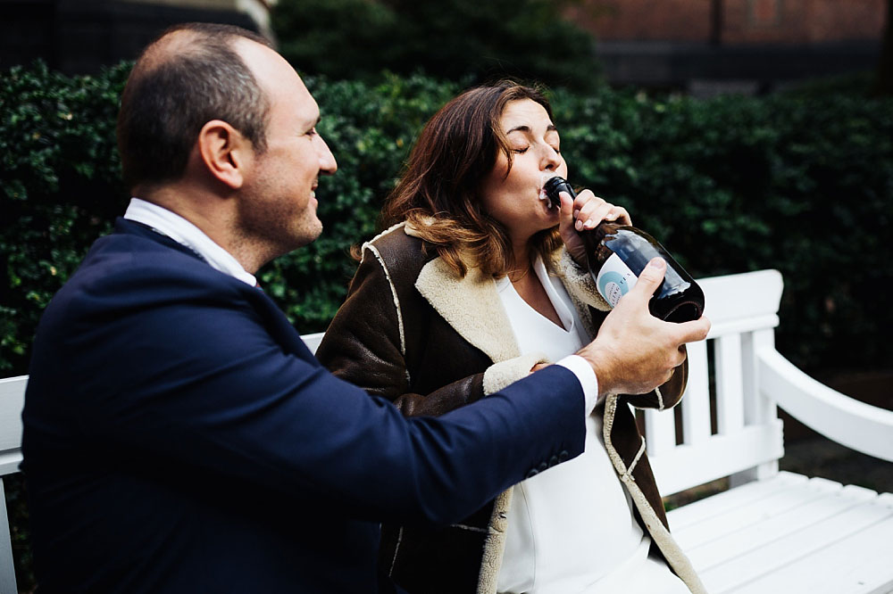 bride and groom drinking Champagne from a bottle at Copenhagen city Hall