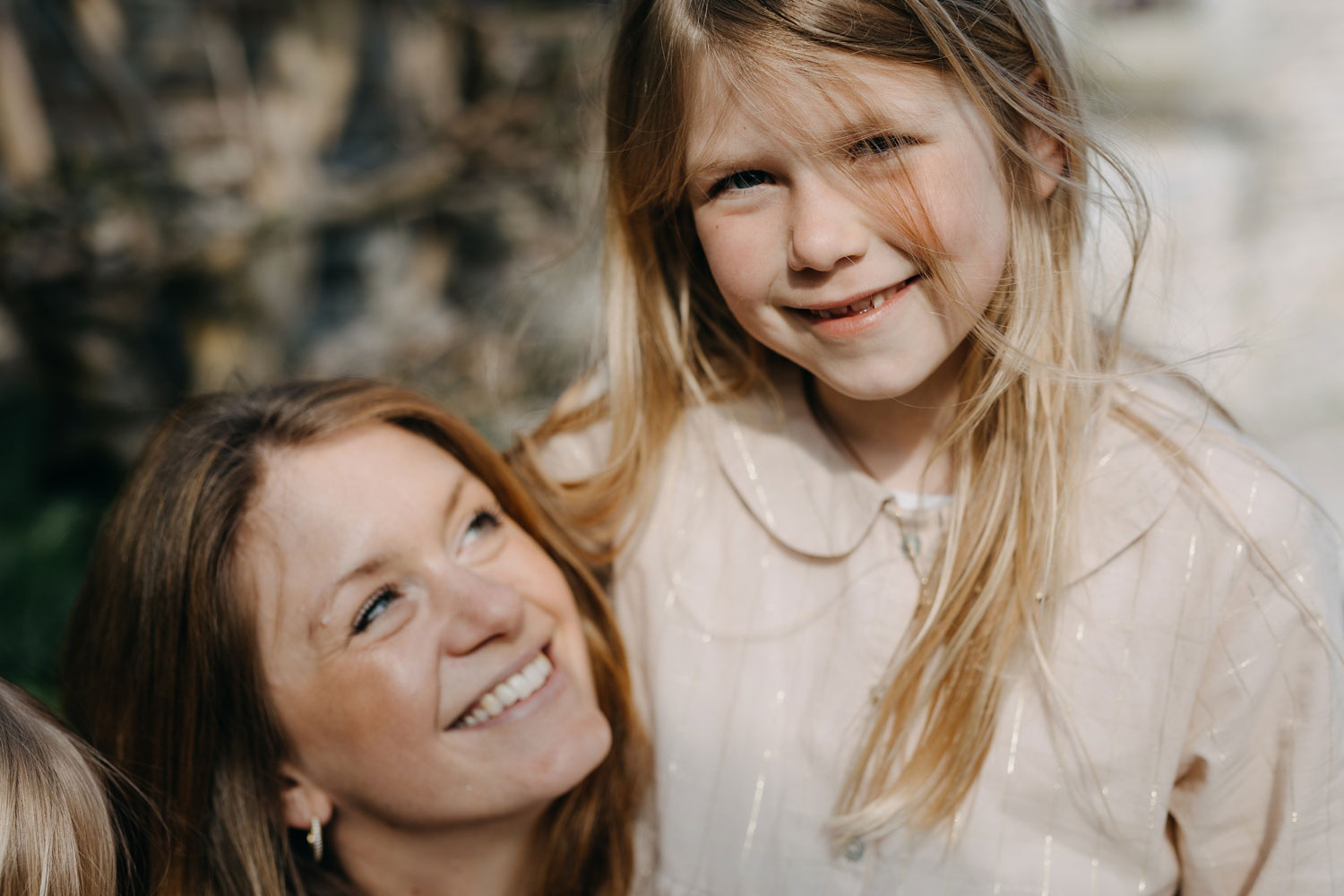 Family portrait: A happy mother posing with her daughters in a park in Copenhagen