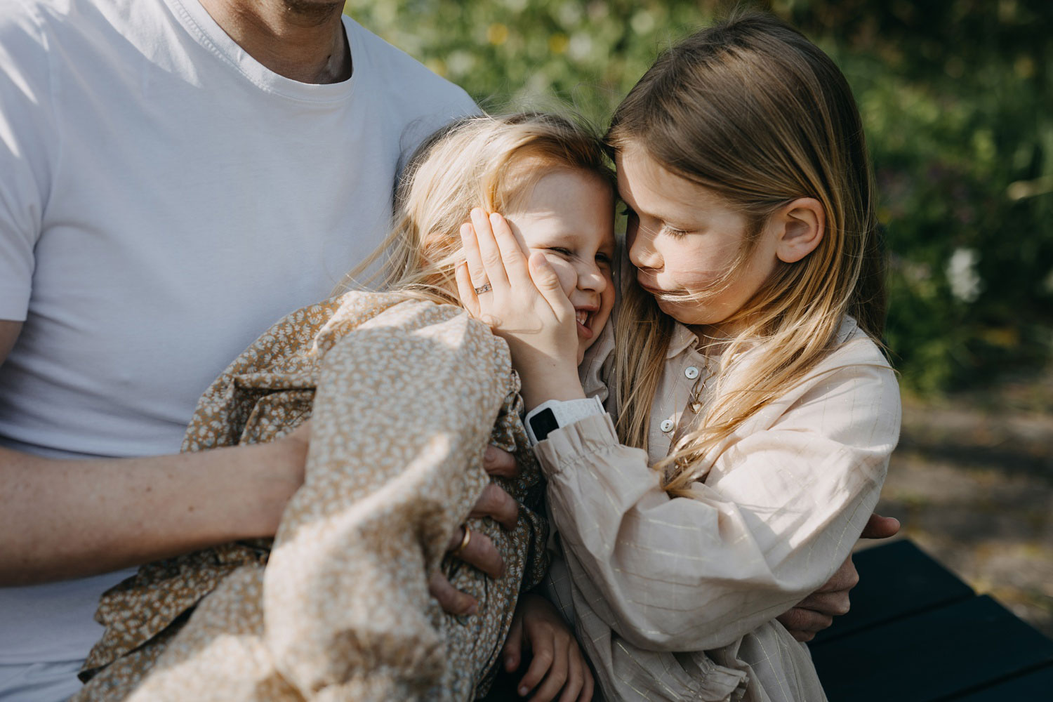 Family portrait in Copenhagen: candid shot of two sisters being cute together in a park in Copenhagen