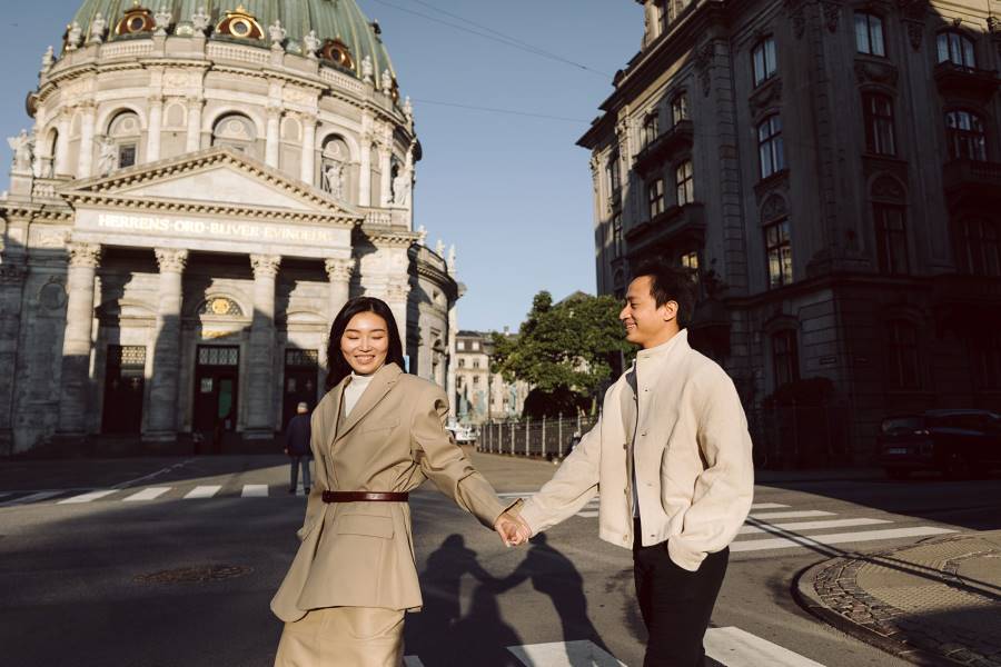 Candid moments of an engaged couple near Copenhagen’s Marble Church, with classic Danish architecture as a backdrop