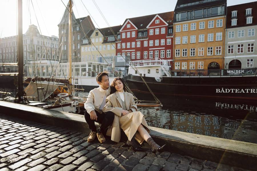 engagement photoshoot in Nyhavn, Copenhagen, capturing a couple by the colorful historic buildings along the waterfront