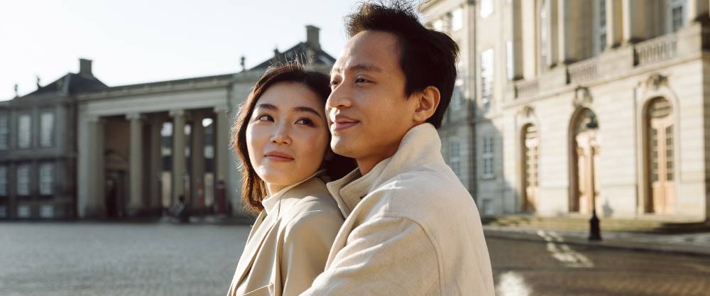 Stylish and romantic engagement photography in Copenhagen showcasing a couple exploring Nyhavn, Amalienborg Palace and Frederik's Church