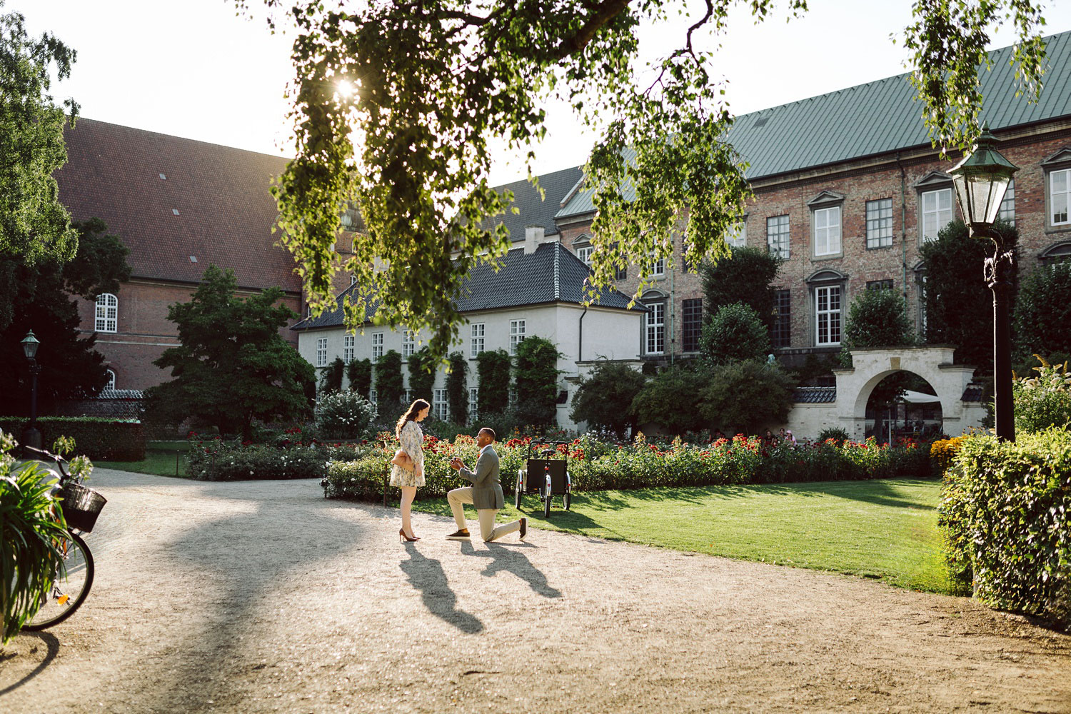 Romantic proposal in the Royal Library Garden, Copenhagen, during golden hour.