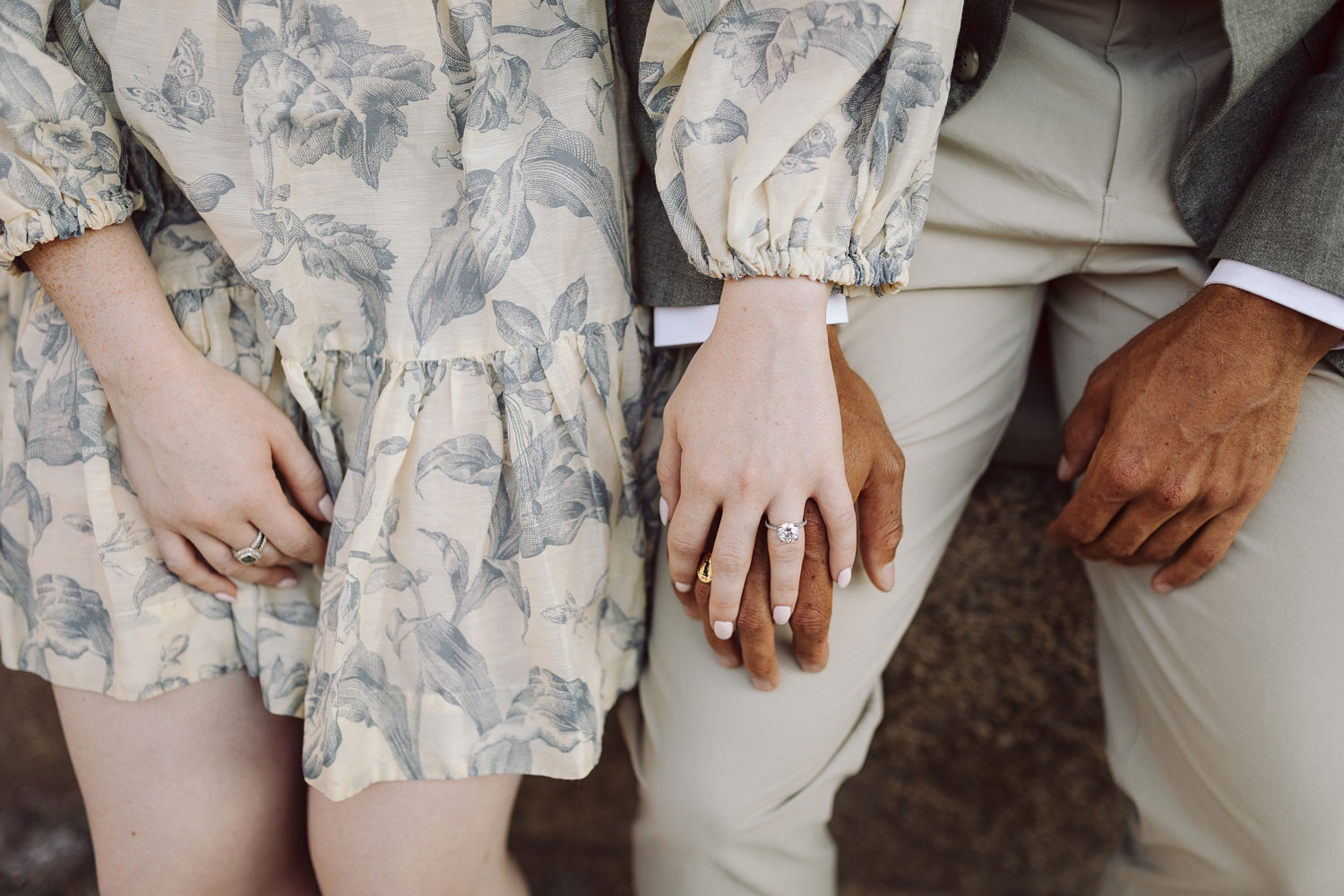 Close-up of the couple holding hands, with the engagement ring