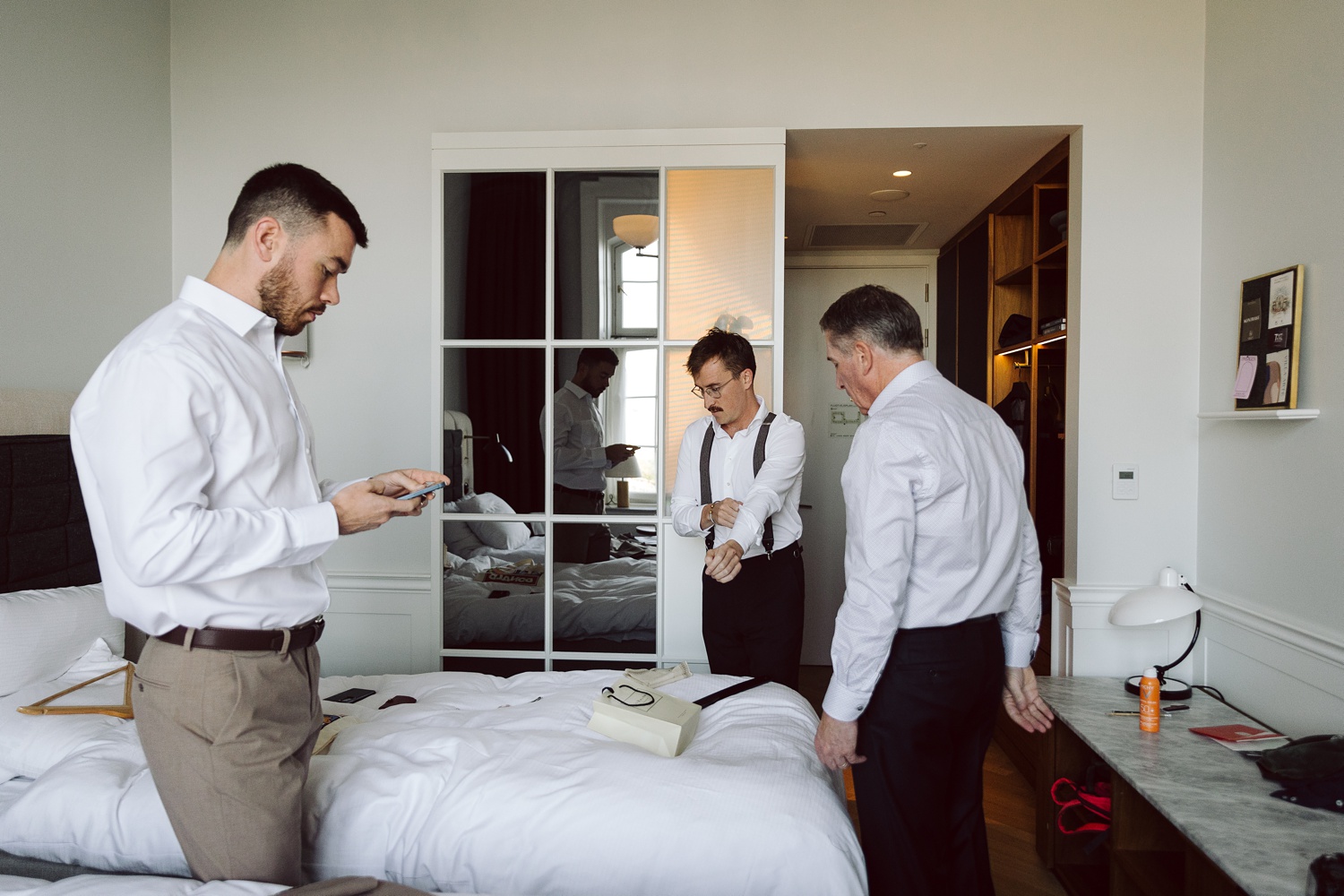 Groom buttoning his suit jacket at Hotel Villa, Copenhagen