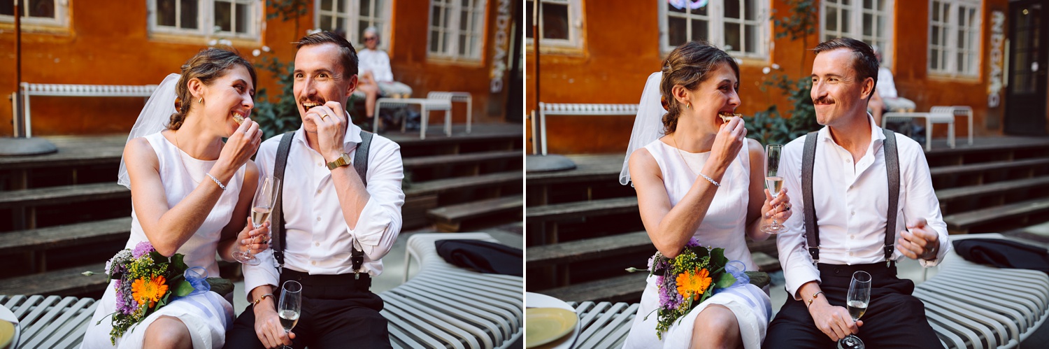 The bride and groom share a delicious Danish pastry at their intimate reception, smiling and savoring the sweet moment together.